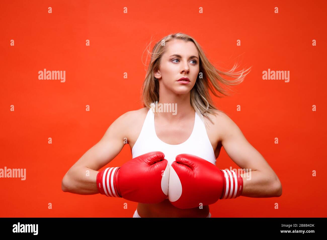 Athletin posiert mit Boxhandschuhen Stockfoto