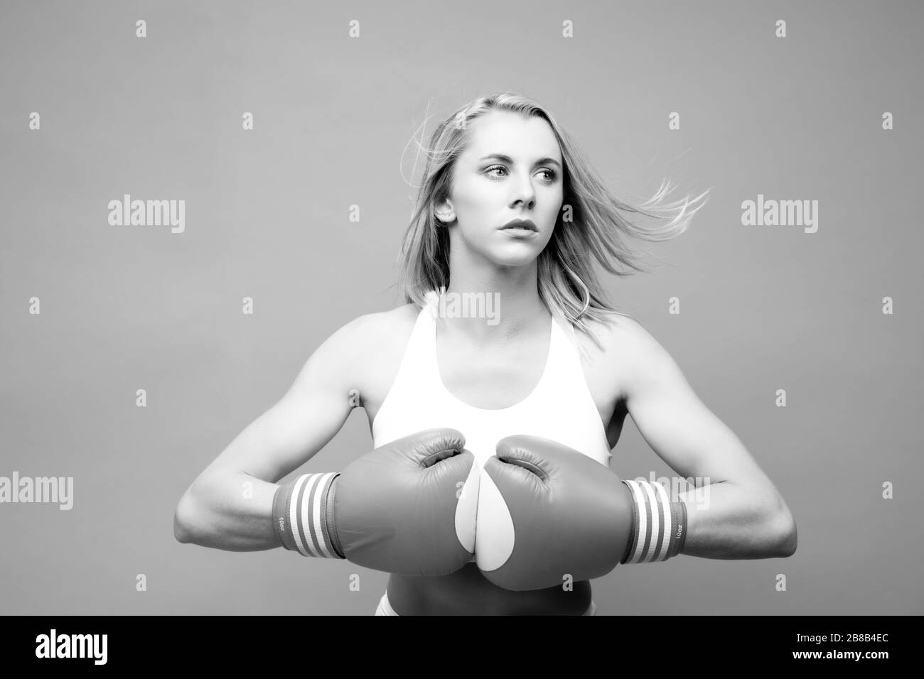 Athletin posiert mit Boxhandschuhen Stockfoto