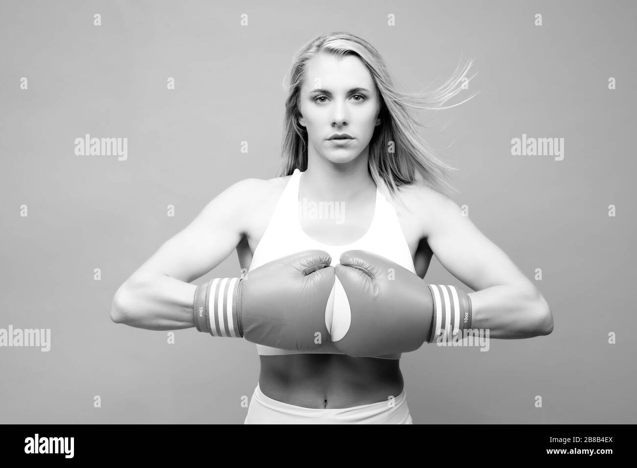 Athletin posiert mit Boxhandschuhen Stockfoto