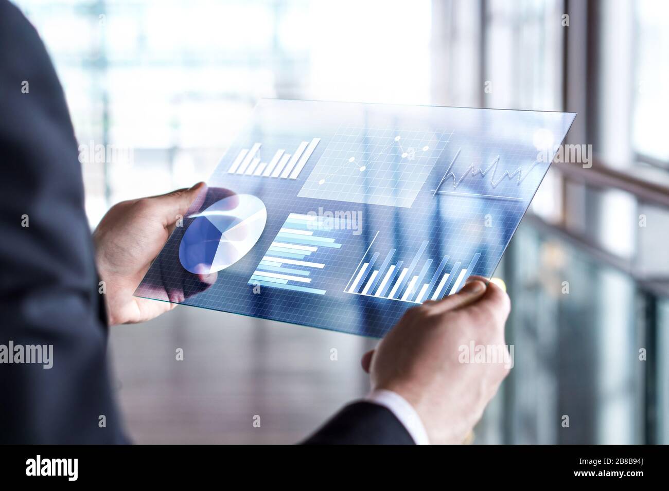 Transparentes futuristisches Tablet. Business man mit virtuellem Touchscreen. Moderne Mobiltechnologie in den Bereichen Buchhaltung, Finanzen, Daten und Analyse. Stockfoto