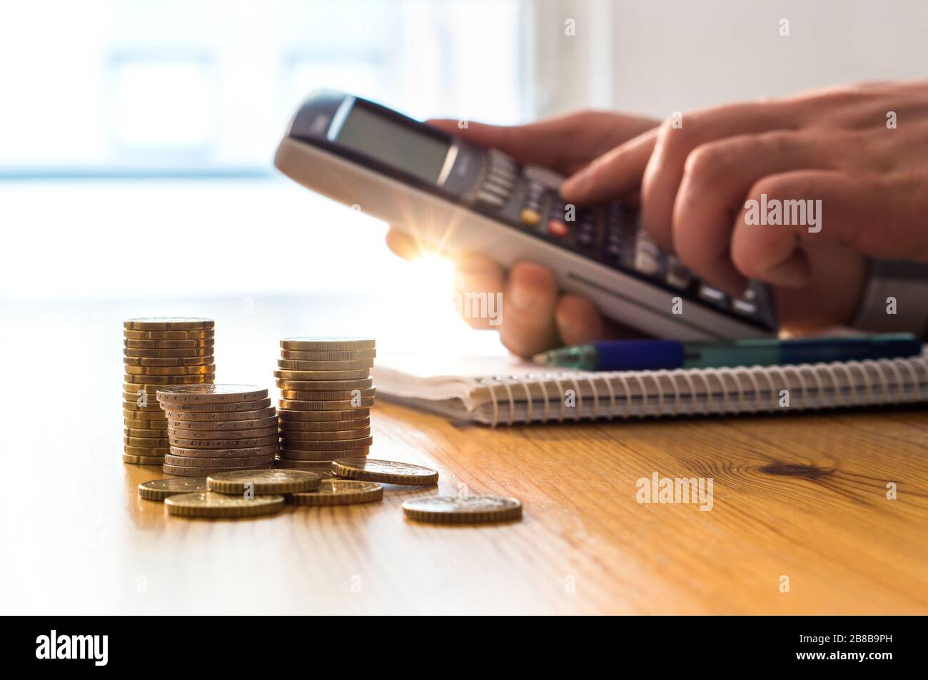 Mann mit Taschenrechner, um Geld- und Lebenshaltungskosten zu zählen. Inflation, Steuern und steigende Ausgaben. Berechnung des täglichen Lebensmittelpreises für die Familie. Stockfoto