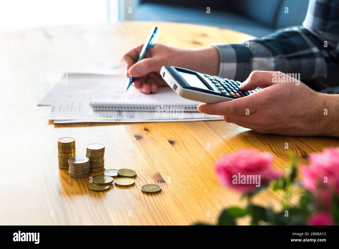 Mann mit Taschenrechner und Budget, Ausgaben und Einsparungen zählen. Konzept für niedrige Einkommenskosten für Familien und steigende Preise. Berechnung und Budgetierung. Stockfoto