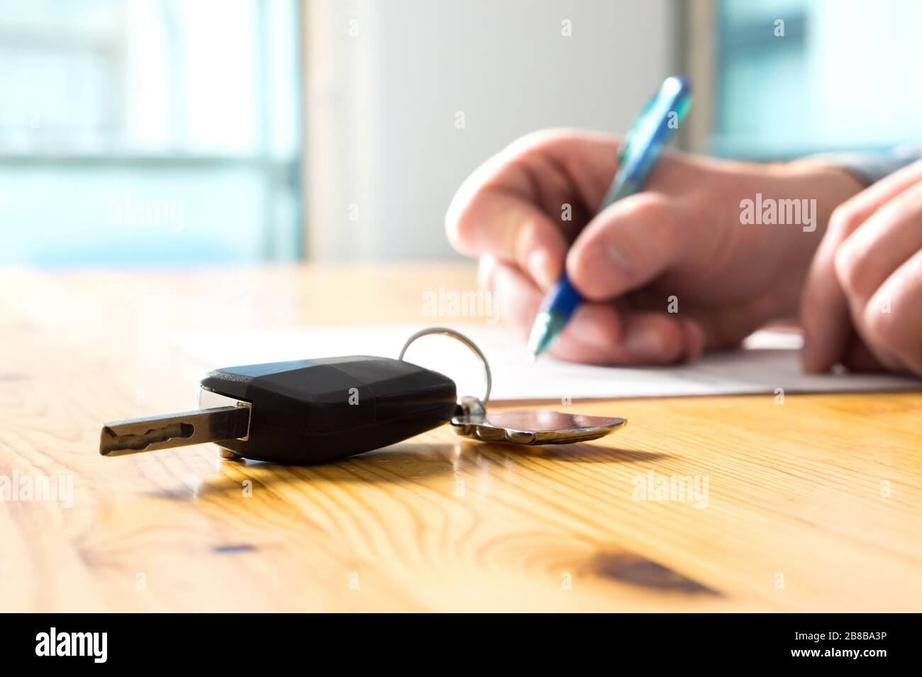 Mann unterschreibt Kfz-Versicherungsdokument oder Pachtpapier. Unterschrift auf Vertrag oder Vertrag schreiben. Kauf oder Verkauf von neuen oder gebrauchten Fahrzeugen. Stockfoto