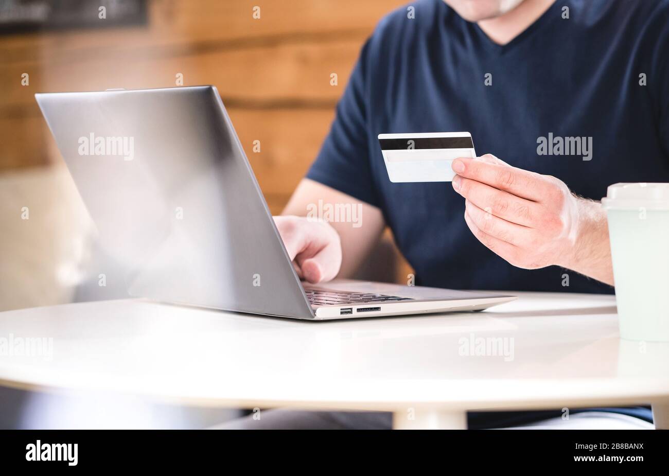 Mann mit Kreditkarte und Eingabe von Bankdaten oder Identifikationsnummern mit Laptop. E-Commerce und Online-Shopping-Konzept. Stockfoto