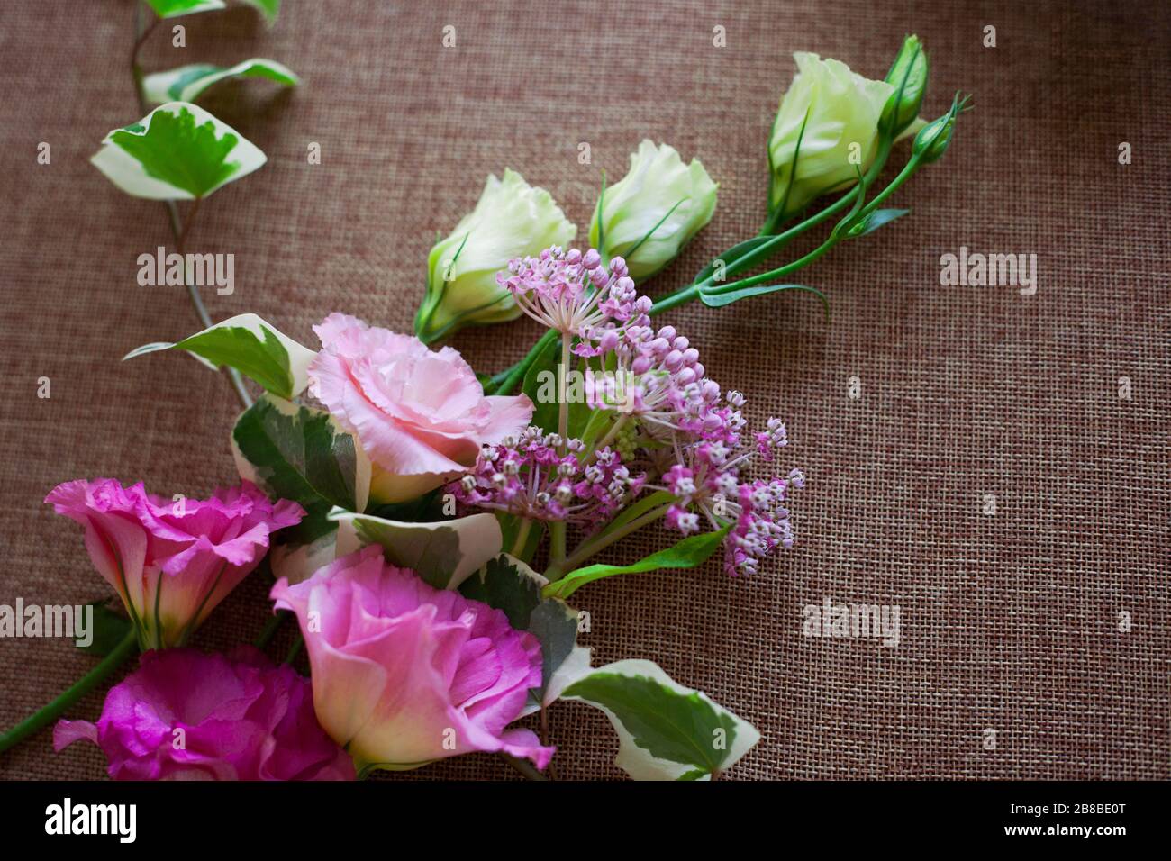 Bouquet schöne Eustoma-Blume (Lisianthus, Tulpengentian, Eustomas) auf sackenden Leinwandtexturhintergrund. Stockfoto