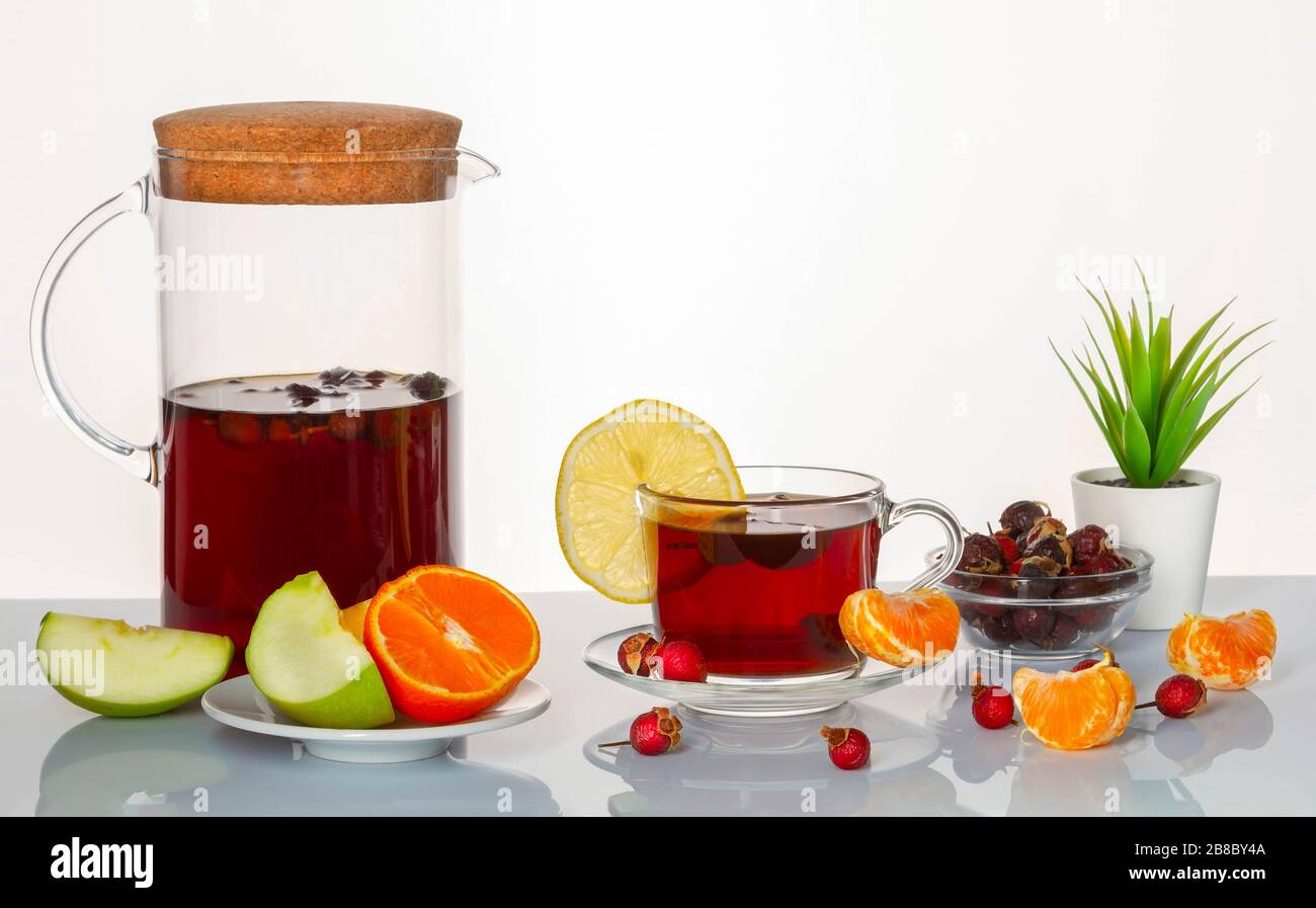 Vermeidung von Erkältungen. Tasse mit Rosehip Infusion, apfel, Zitrone und Mandarin auf einer Spiegeloberfläche. Stockfoto