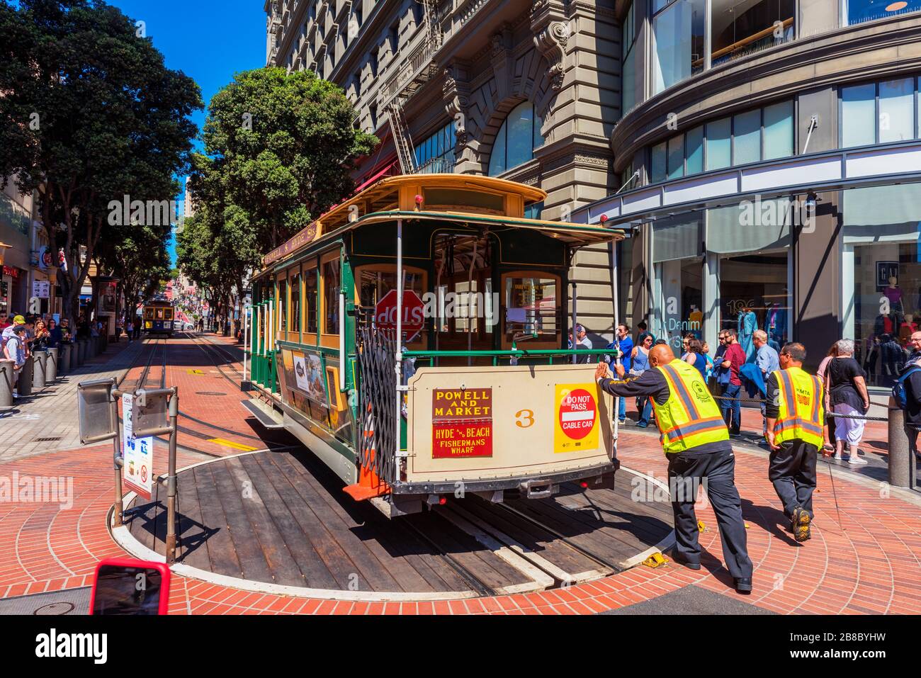 Der Fahrer schiebt eine Seilbahn, nachdem er sie in umgekehrter Richtung am Powell und Market Street Turntable in San Francisco USA gedreht hat Stockfoto