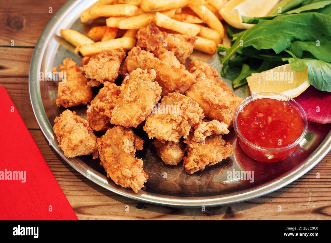 Frittierte Muscheln in einem Teller mit Sauce und pommes frites auf einem Holz-Restauranttisch Stockfoto