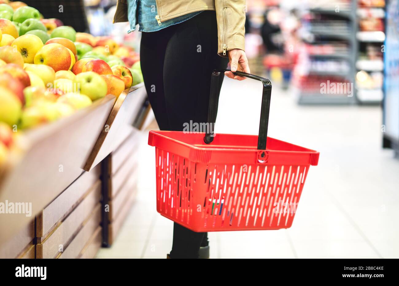 Konzept für Einzelhandel, Verkauf und Konsumerismus. Kunde im Supermarkt Gemüse- und Obstbereich, der gesunde Lebensmittel wählt. Frau mit Warenkorb. Stockfoto