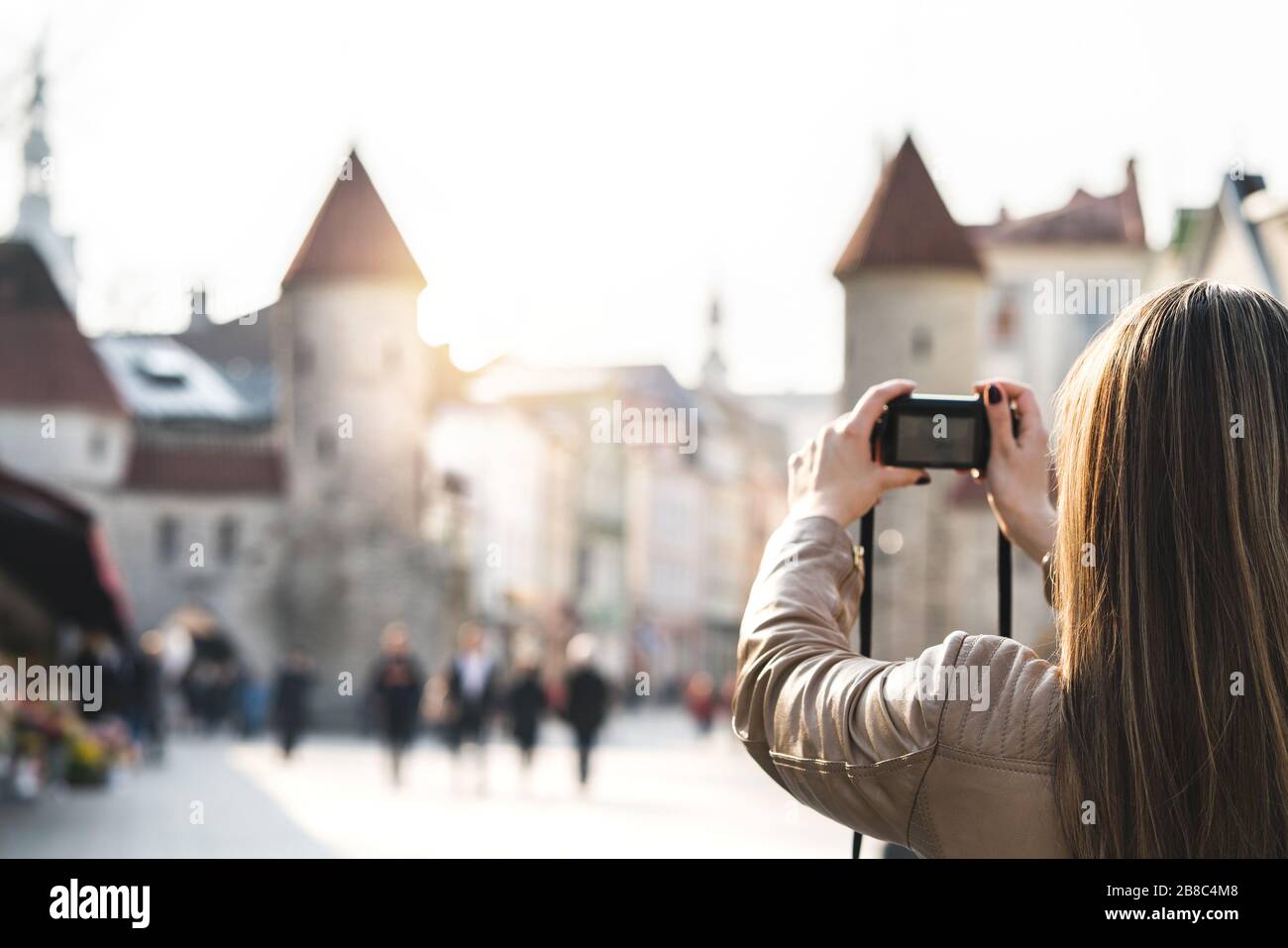 Frau in Tallinn fotografieren Viru-Tor. Touristen im Urlaub, die ein Bild vom Wahrzeichen Estlands machen. Menschen, die in einer beliebten Straße spazieren gehen. Stockfoto