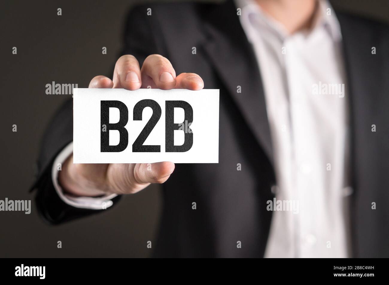 B2B- und Business-to-Business-Marketing-Konzept. Geschäftsmann, der eine Karte mit Text hält. Stockfoto