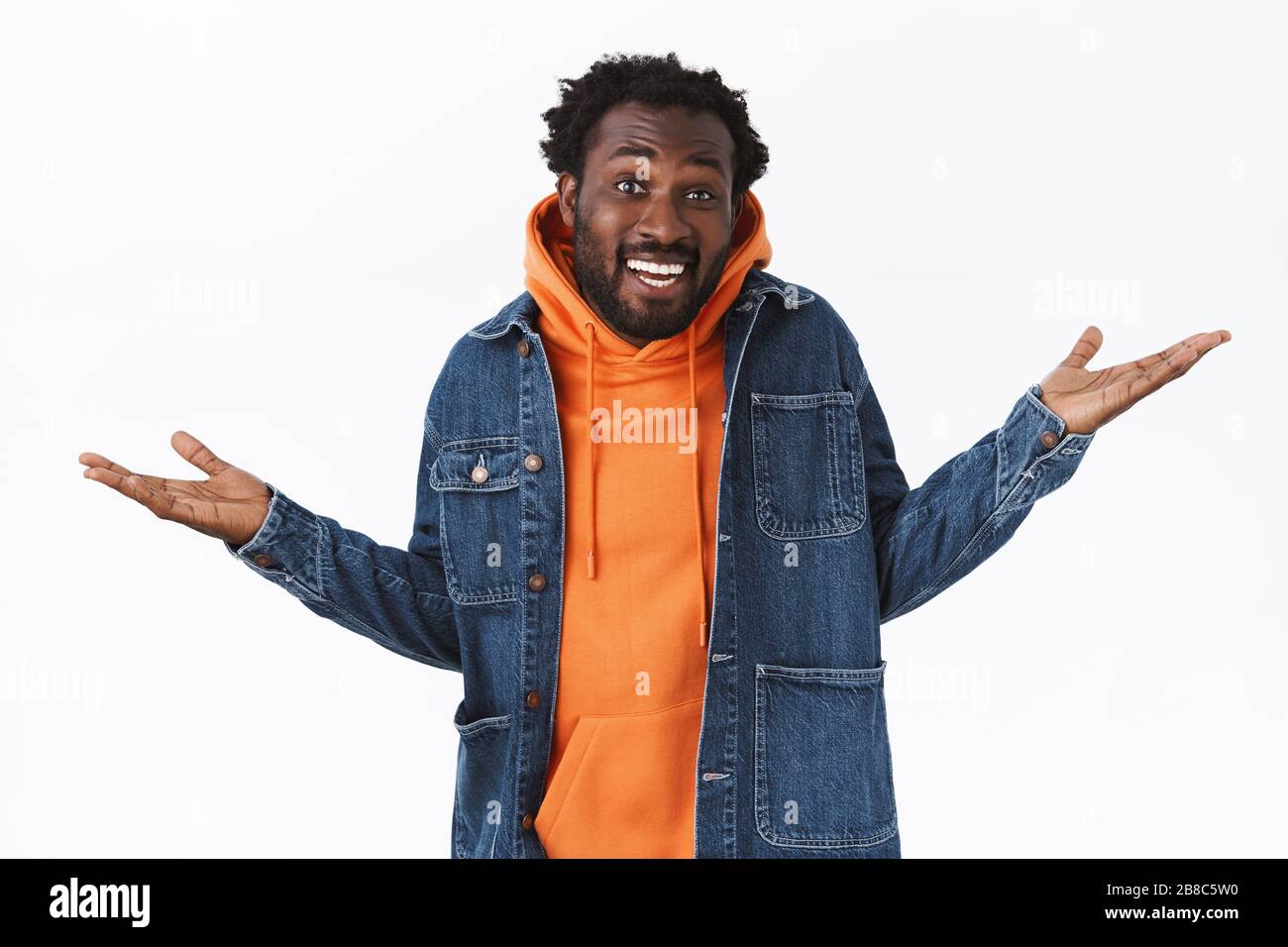 Unbeschwert unbesorgt cooler stiller afroamerikanischer bärtiger Mann, Hände seitlich entspannt und chill, lächelnder Schüttelkopf ratlos, keine Sorgen Stockfoto