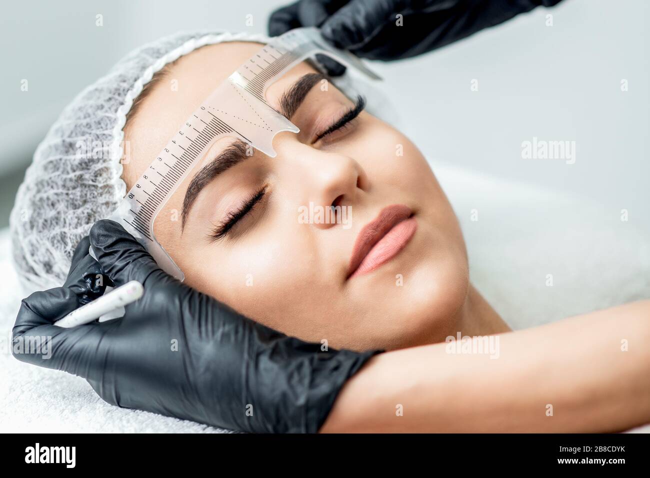 Markup mit Lineal an den Augenbrauen der yong-frau während des permanenten Make-up. Stockfoto