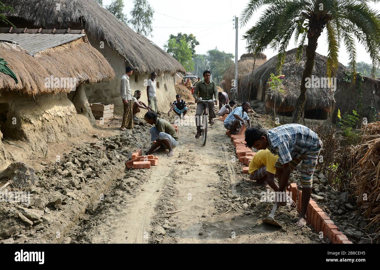 Ländliche Entwicklung - die ländlichen Dorfbewohner bauen ihre eigene Dorfstraße mit Steinen für die Entwicklung ihres Lebensstils und ihrer Kommunikation auf. Stockfoto