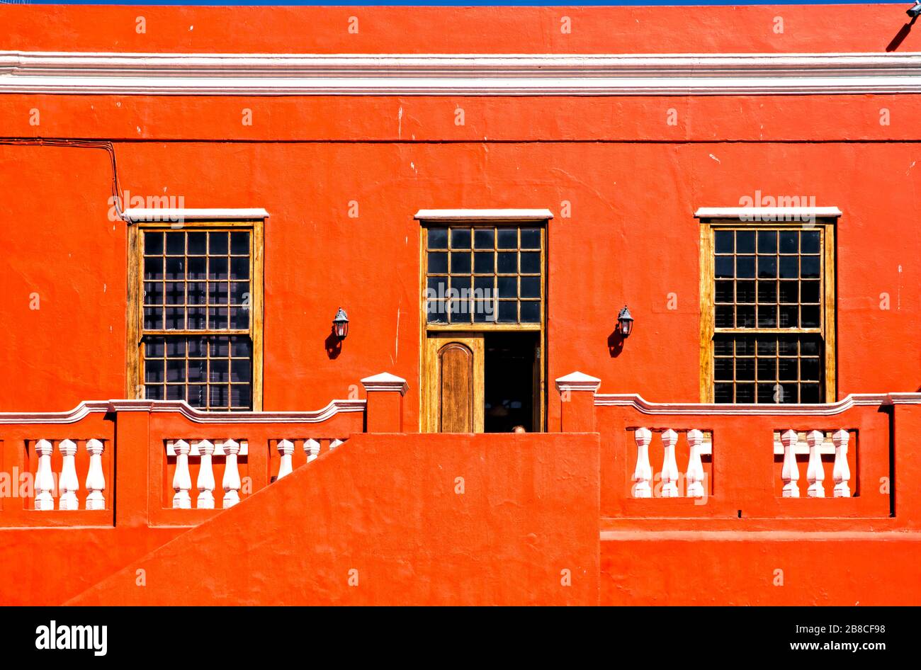 Weiße Details auf Block orange, ergänzt durch ein Trio von verglasten Fenstern. Alles in perfekter Balance in 79 Wale Street, Bo-Kaap. Stockfoto