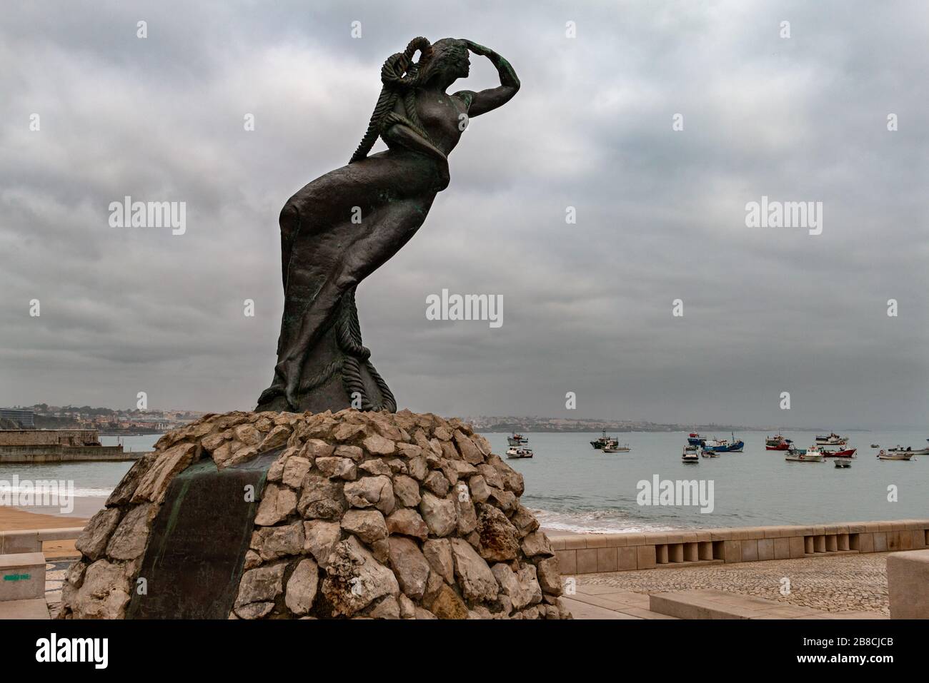 Cascais, Portugal - 10. Februar 2020: Statue einer weiblichen Figur blickt auf See, bis die Fischer sicher in den Hafen zurückkehren. Stockfoto
