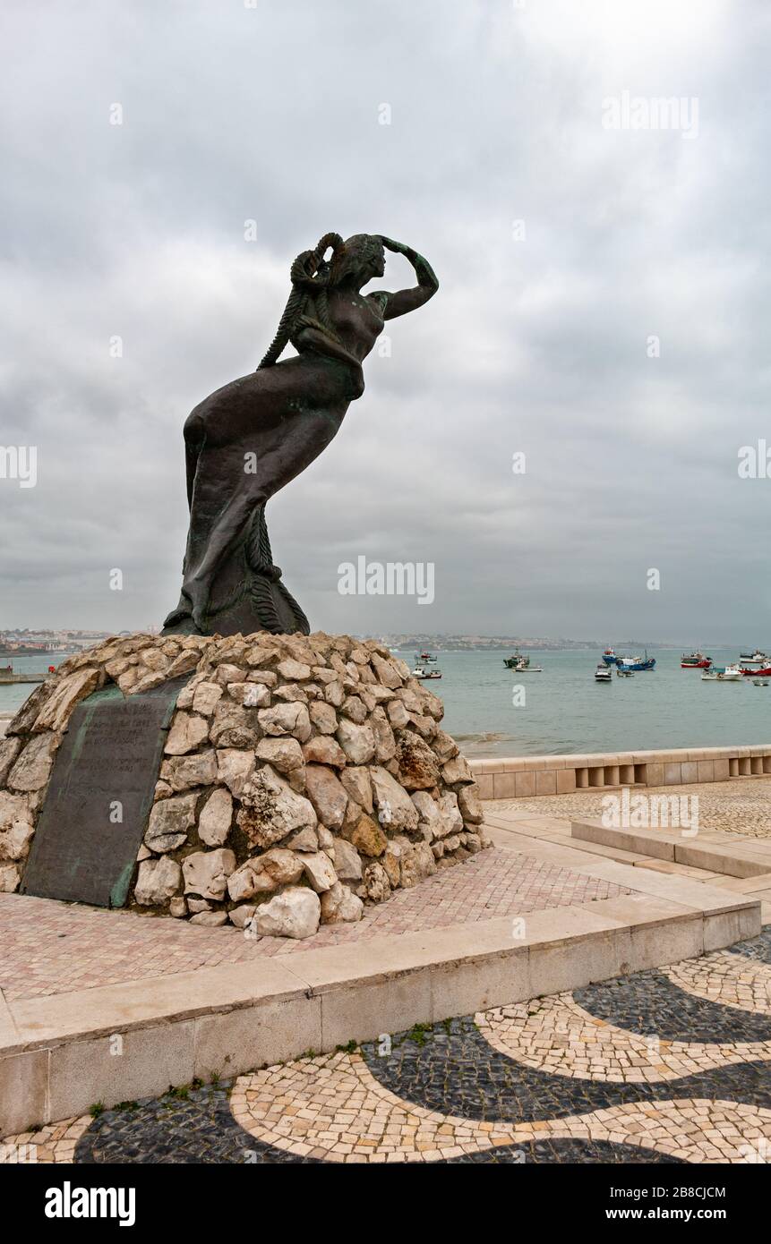Cascais, Portugal - 10. Februar 2020: Statue einer weiblichen Figur blickt auf See, bis die Fischer sicher in den Hafen zurückkehren. Stockfoto