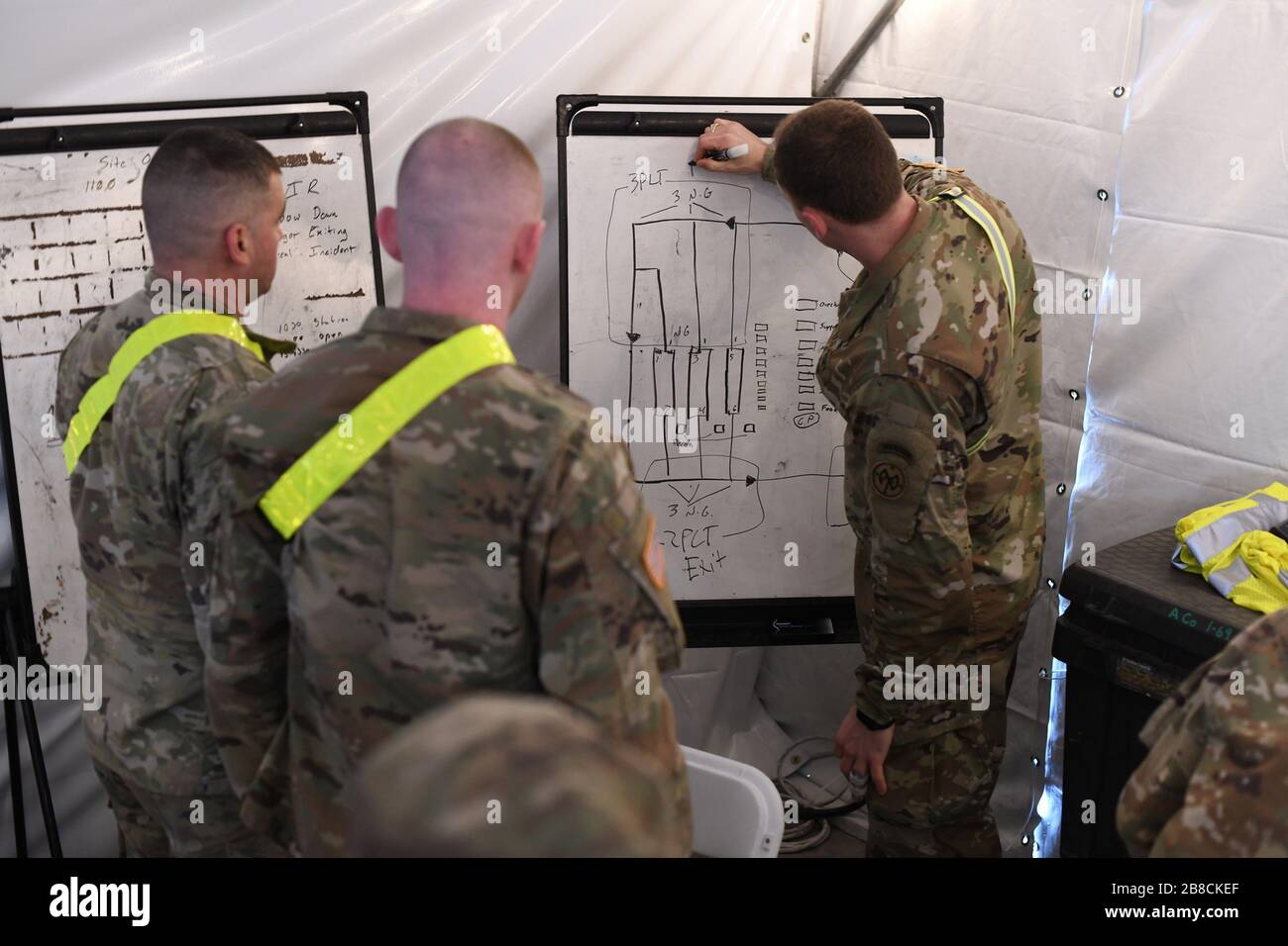 Staten Island, Vereinigte Staaten. März 2020. CPT Miles Kirwin, Commander of Alpha Company, 1st Battalion, 69th Infantry, New York Army National Guard, informiert Teammitglieder über Truppenstützpunkte, bevor das Drive-Through COVID-19 Mobile Testing Center am South Beach Behavioral Center, Staten Island, New York am 19. März 2020 eröffnet wird. Mitglieder der New Yorker Armee und der Air National Guard wurden im Rahmen der Operation COVID-19 aktiviert, um staatliche und lokale Reaktionsmaßnahmen zu unterstützen. Foto von Maj Patrick Cordova/USA Air National Guard/UPI Credit: UPI/Alamy Live News Stockfoto