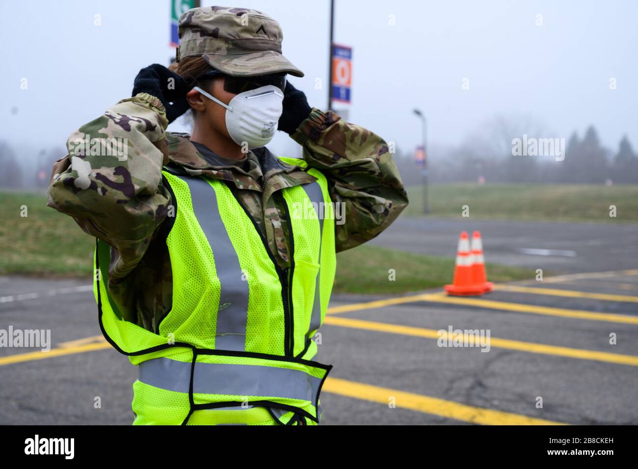 Paramus, NJ, USA. März 2020. Nationalgarde Der New Jersey Army Pvt. Bethanie Keir, eine Soldatin der 508th Military Police Company, legt ihre Schutzmaske am 20. März 2020 an einer COVID-19-Community-basierten Teststelle am Bergen Community College in Paramus, New Jersey, auf. Der in Partnerschaft mit der Federal Emergency Management Agency (FEMA) eingerichtete Teststandort war mit dem Gesundheitsministerium von New Jersey, der Staatspolizei von New Jersey und der Nationalgarde von New Jersey besetzt. Das Drive-Thru-Testzentrum ist sieben Tage pro Woche geöffnet, von 8:00 Uhr bis 16:00 Uhr. Gutschein: UPI/Alam Stockfoto