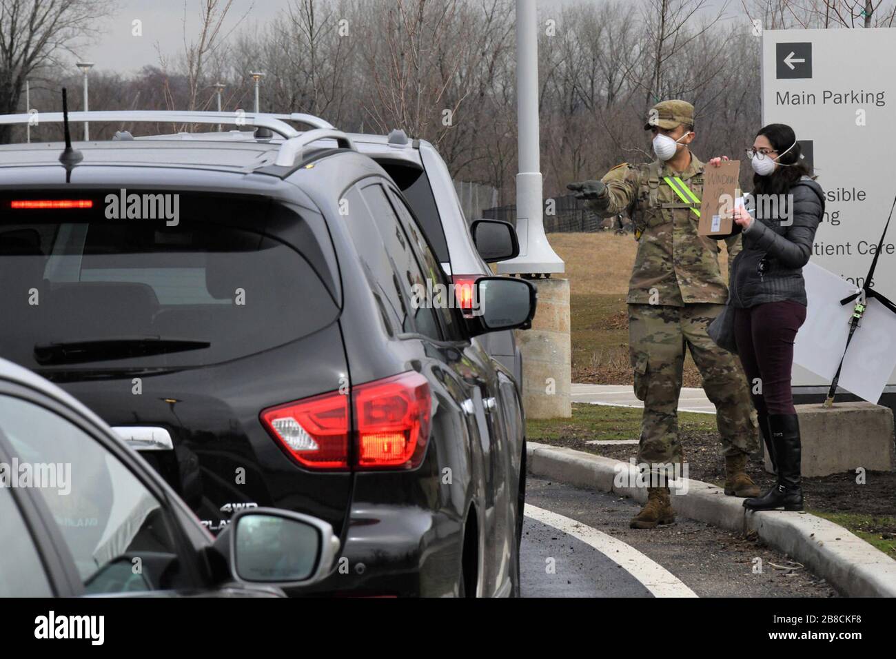 Staten Island, Vereinigte Staaten. März 2020. Ein Soldat der Nationalgarde der New Yorker Armee und ein Zivilarbeiter führen am 19. März 2020 den direkten Verkehr in einem Drive-Through COVID-19 Mobile Testing Center im South Beach Behavioral Center, Staten Island, New York. Derzeit werden nur Personen mit einem Termin an der Prüfstelle entnommen. Mitglieder der New Yorker Armee und der Air National Guard von A wurden im Rahmen der Operation COVID-19 aktiviert, um die staatlichen und lokalen Bemühungen zu unterstützen. Foto von Maj Patrick Cordova/USA Air National Guard/UPI Credit: UPI/Alamy Live News Stockfoto Staten Island, Vereinigte Staaten. März 2020. Ein Soldat der Nationalgarde der New Yorker Armee und ein Zivilarbeiter führen am 19. März 2020 den direkten Verkehr in einem Drive-Through COVID-19 Mobile Testing Center im South Beach Behavioral Center, Staten Island, New York. Derzeit werden nur Personen mit einem Termin an der Prüfstelle entnommen. Mitglieder der New Yorker Armee und der Air National Guard von A wurden im Rahmen der Operation COVID-19 aktiviert, um die staatlichen und lokalen Bemühungen zu unterstützen. Foto von Maj Patrick Cordova/USA Air National Guard/UPI Credit: UPI/Alamy Live News Stockfoto