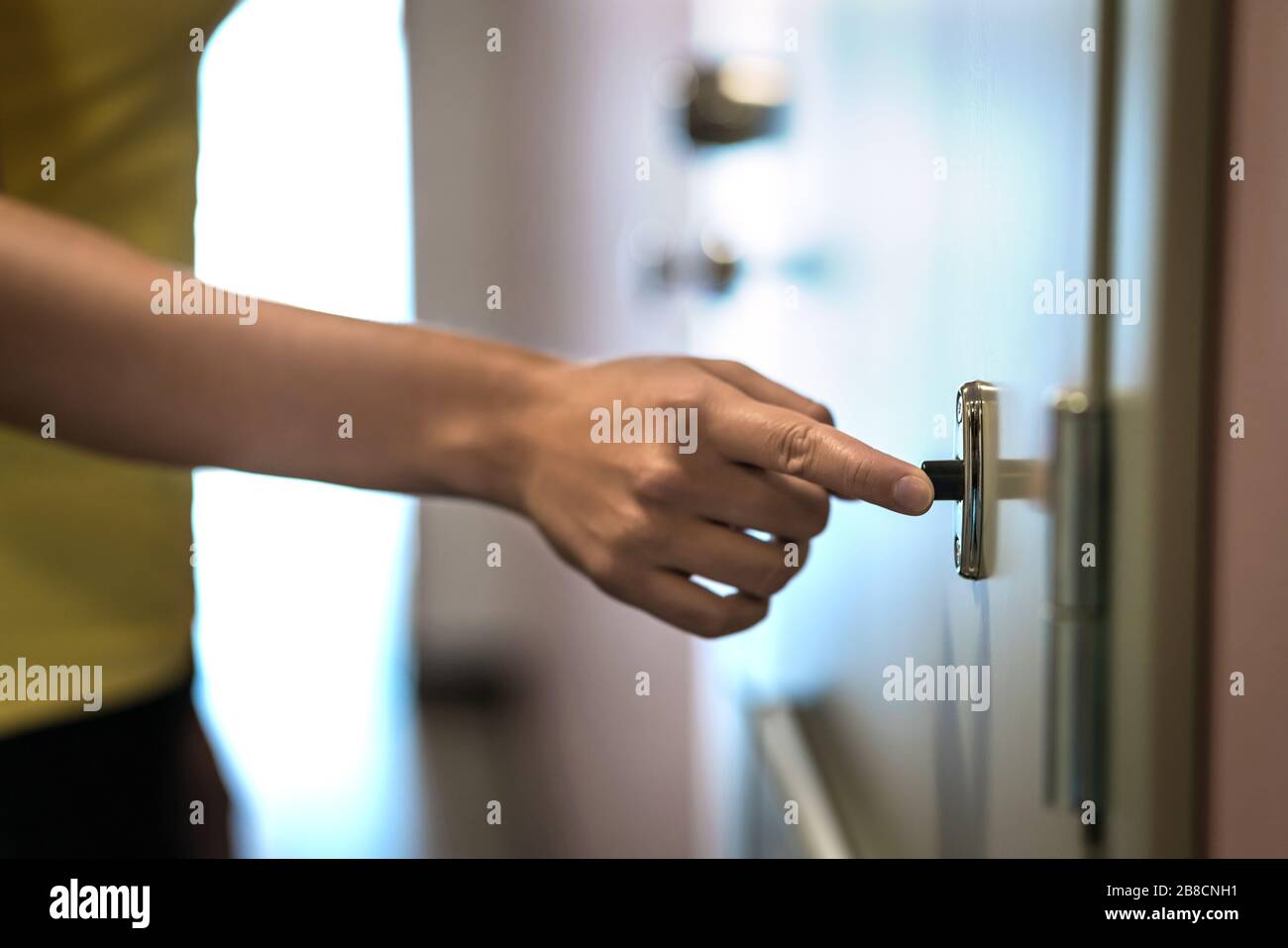 Hand auf Türklingel. Klingende Türklingel. Nachbar oder weibliche Gäste überraschen einen Besuch. Stockfoto