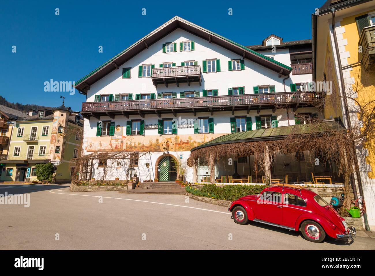 St. Gilgen, Österreich - 20. März 2020: Roter Volkswagen Käfer im Retro-Look vor dem Hotel Gasthof zur Post am Mozartplatz geparkt. Stockfoto