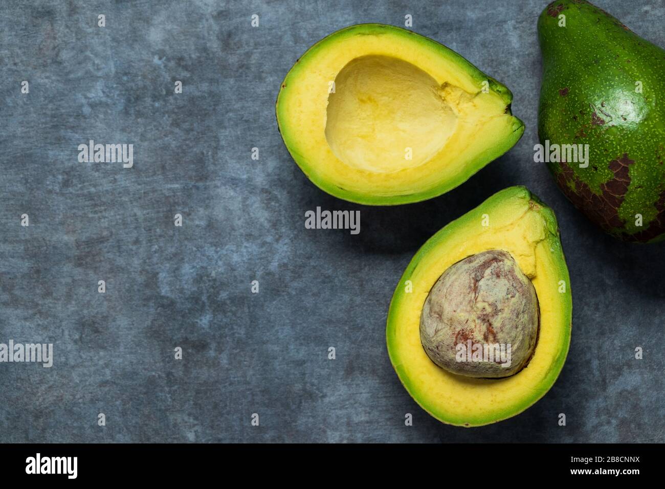 Frischer Avocado wird halbiert. Sie sind hoch in der gesunden Art von Fetten Stockfoto