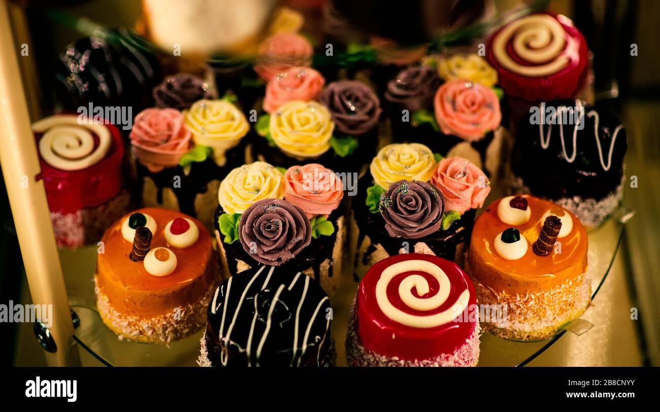 Nahaufnahme verschiedener süßer Cupcakes, selektiv fokussiert, vor einem bokehen Hintergrund. Stockfoto