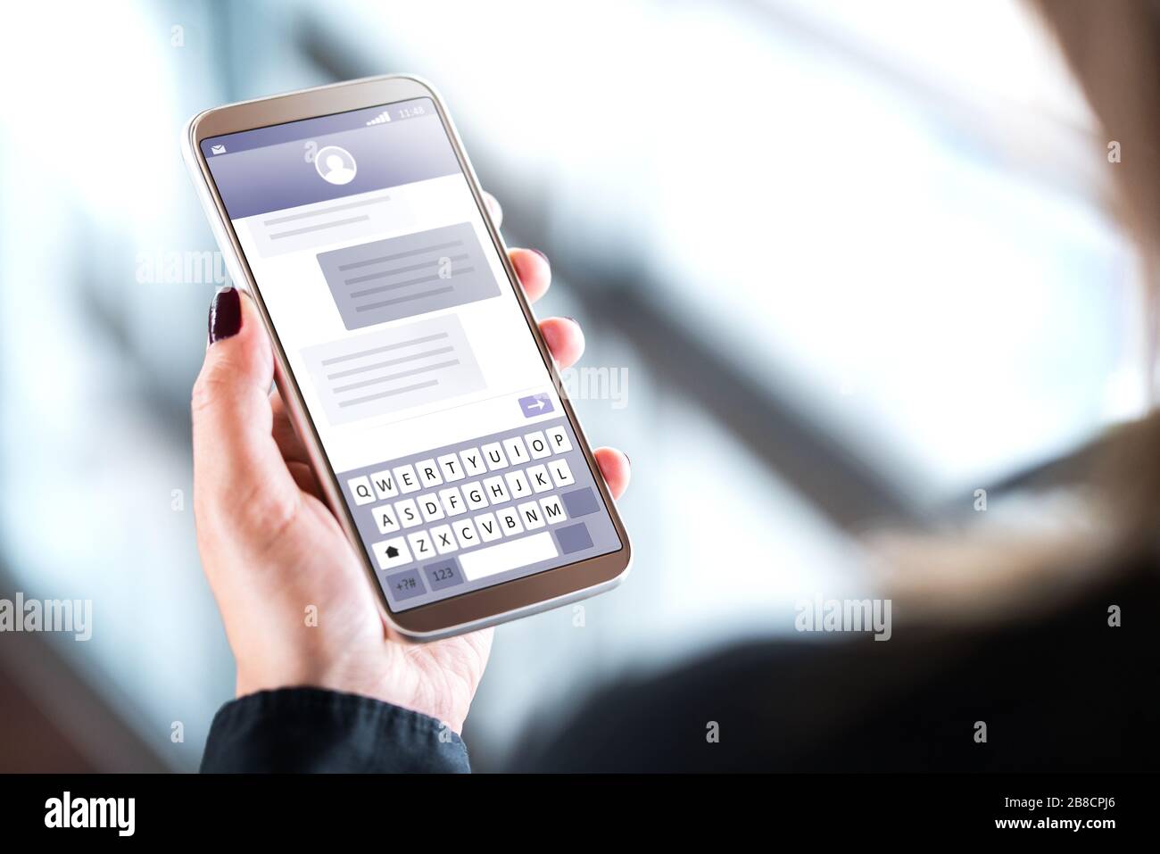 Frau, die SMS mit dem Handy sendet. Handy in der Hand mit sms-Anwendung auf dem Bildschirm. Person, die Instant Messaging-Software verwendet. Stockfoto