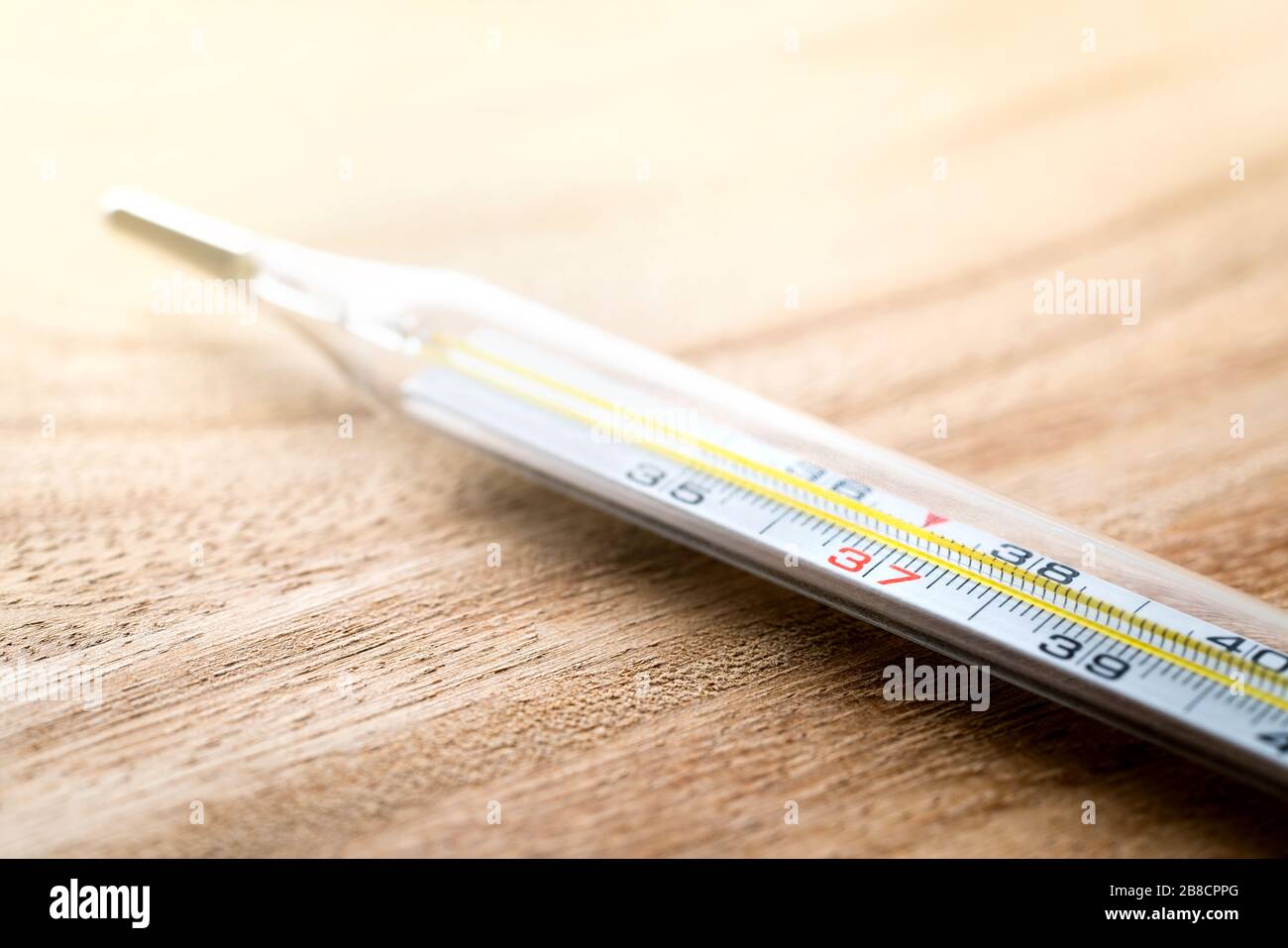 Celsius Thermometer auf Holztisch. Fieber, Grippe, Krankheit, Virus und krankes Konzept. Körpertemperaturmessung im Gesundheitswesen. Stockfoto