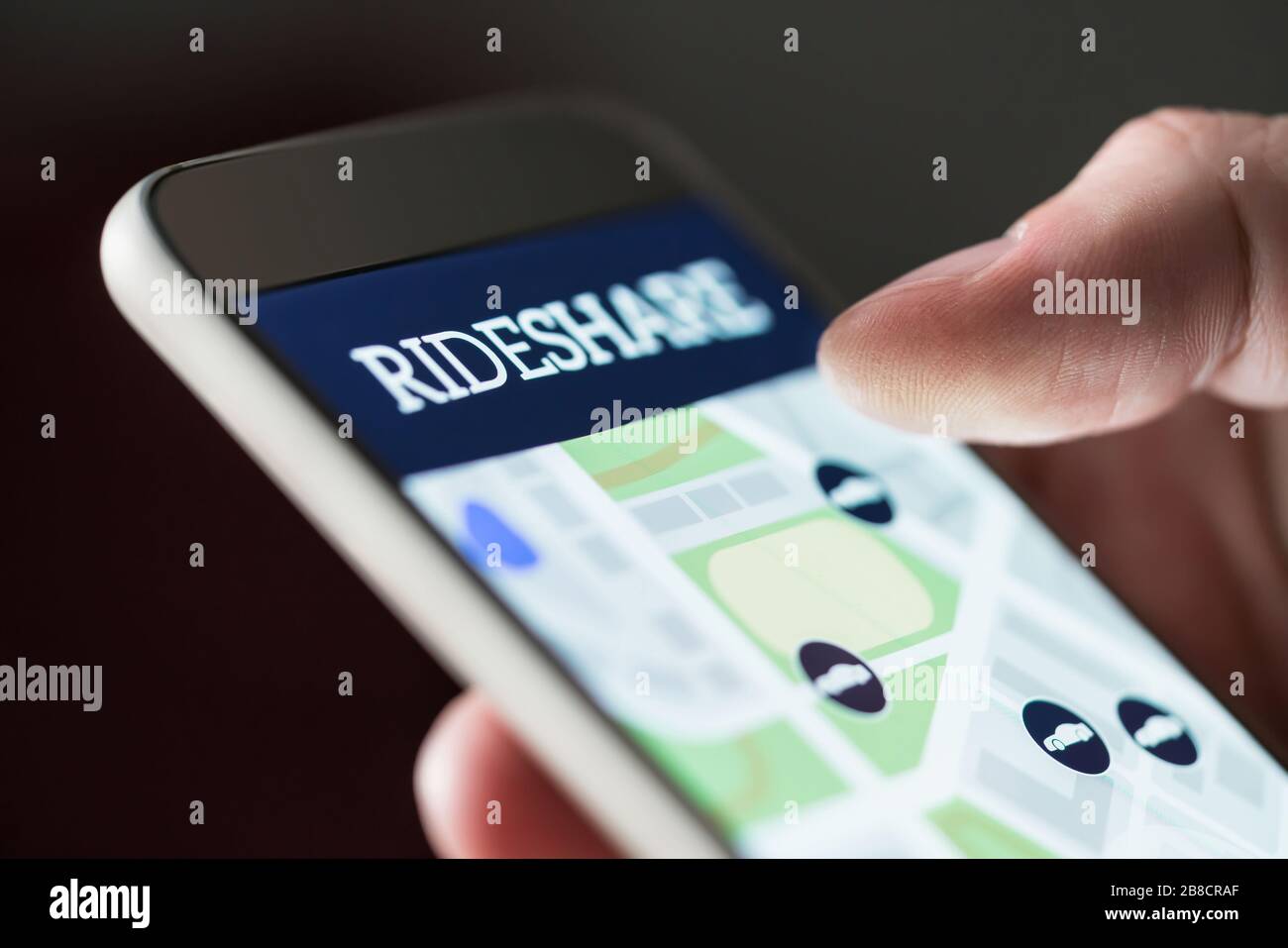 Mit der App "Teilen" auf dem Smartphone. Mann mit Rideshare Taxi-Anwendung. Online-Carpool oder Carsharing-Service auf dem Handy. Stockfoto