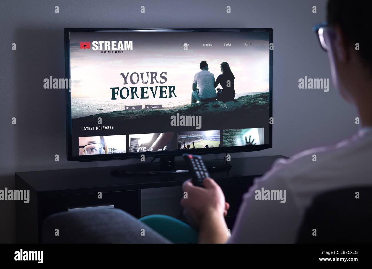 Online-Filmstreamdienst in Smart tv. Streaming-Serie mit VOD-Dienst (On Demand Video) im Fernsehen. Mann, der sich für einen Film mit Fernbedienung entscheidet. Stockfoto