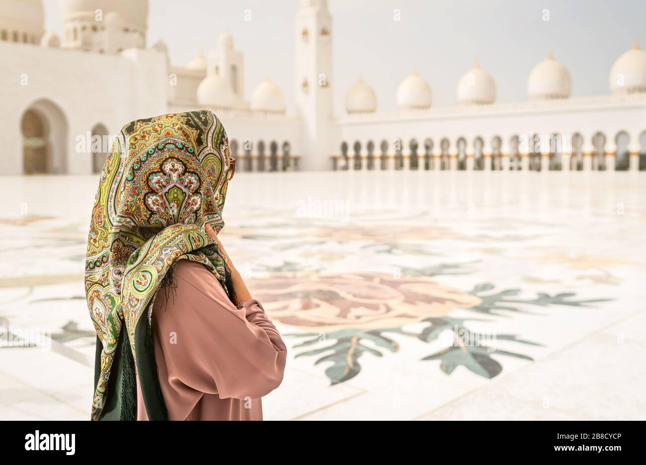Blick auf die Frau in der Scheich Zayed Grand Moschee. Traditionelles muslimisches Gebäude in den Vereinigten Arabischen Emiraten. Weibliche Besucherin mit Kopftuch. Stockfoto