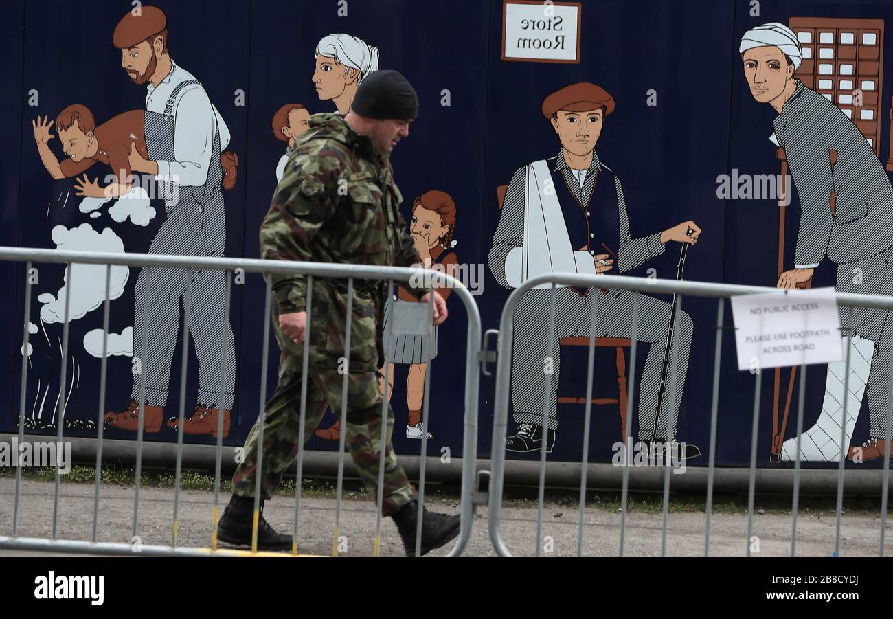 Ein Mitglied der Verteidigungskräfte an Sir John Rogersons Quay in Dublin als Zelte der Verteidigungskräfte wurde neben dem L Samuel Beckett vor dem Einsatz als Testzentrum für Covid-19 aufgestellt. Stockfoto