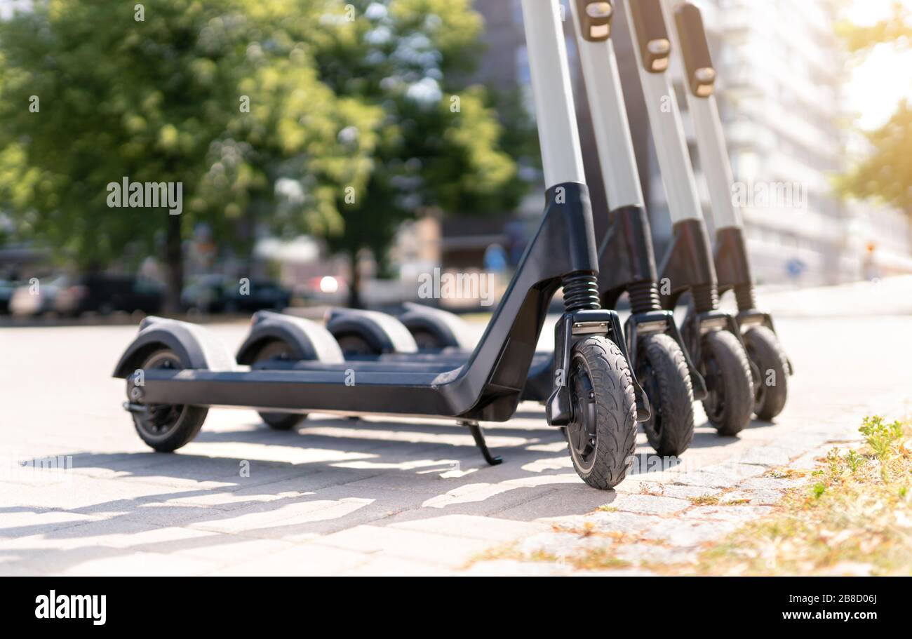 Abgeschnittene Ansicht von elektrischen Rollern in der Stadt, die gemietet werden können. Städtische, moderne Verkehrsmittel und Technologie. Stockfoto