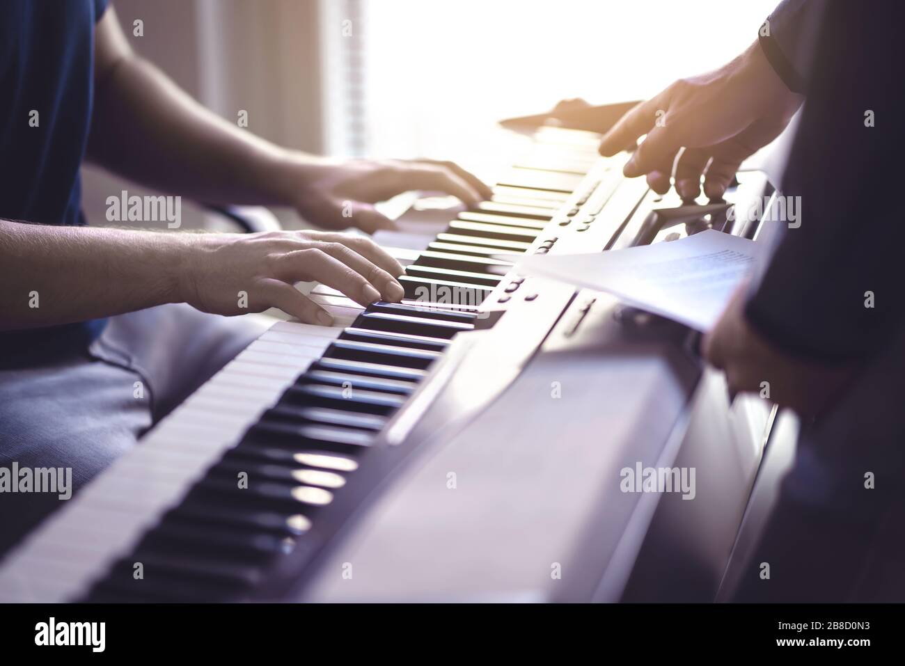 Musikunterricht und -Kurs. Klavierlehrer und Schüler, die in der Schule praktizieren. Man lernt mit Tutor im Unterricht spielen. Zwei Jungs trainieren. Mentor-Unterricht. Stockfoto