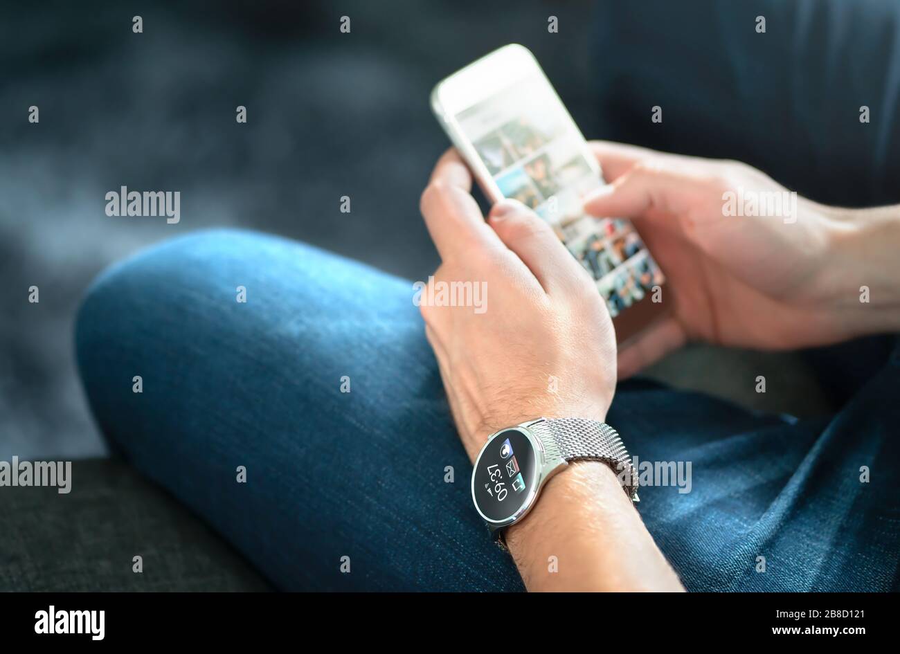 Drahtlose Verbindung zwischen Smart Watch und Mobiltelefon. Mann, der tragbare Geräte und digitale Apps verwendet. Person, die zukünftige Armbanduhr in der Hand trägt. Stockfoto