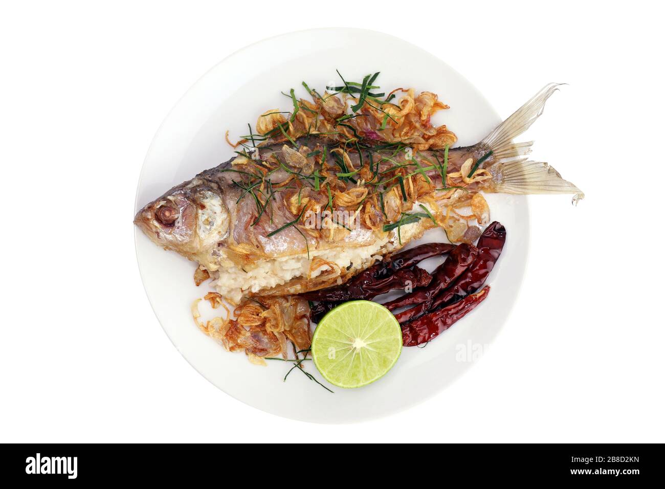 Gebackene Fische schmackhaft gebraten (Pla som tod: thailändisches Wort), gebackene Fischbraten und gebratene Zwiebeln, Limettenscheibe und gebratene Chili mit frischem Gemüse auf Weiß serviert Stockfoto