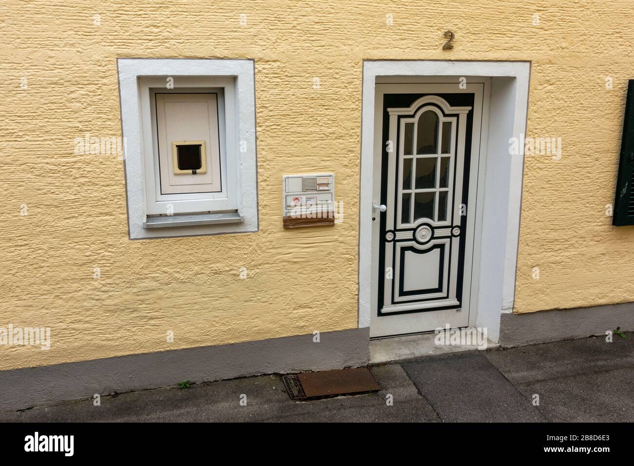 Ungewöhnliches Anwesen mit einer Katzenklappe in einem Fenster (anstatt der Tür), in Oberschleißheim, München, Bayern, Deutschland. Stockfoto