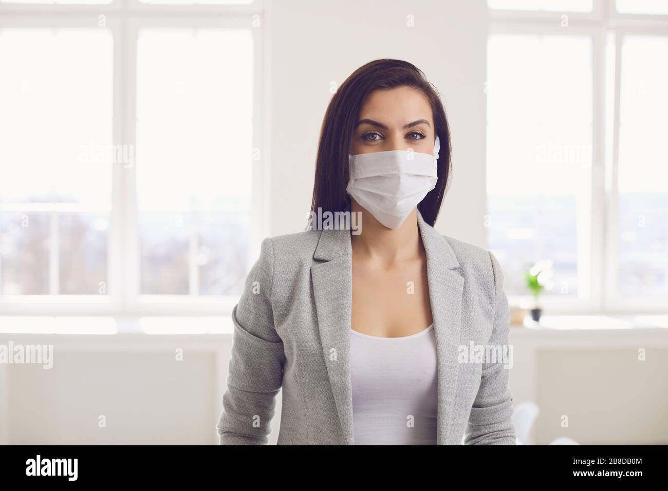 Infektionsgefahr der Virus-Coronavirus-Infektion. Geschäftsfrau in medizinischer Maske im Büro Stockfoto