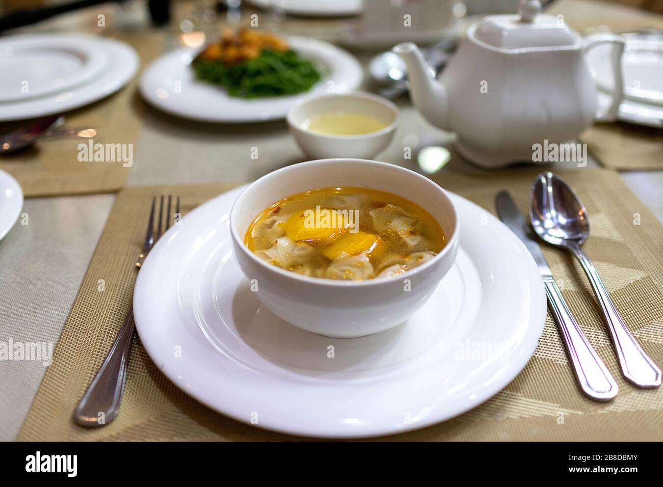 Usbekische Suppe in weißer Schüssel auf dem Tisch im Restaurant, Usbekistan, Chiwa Stockfoto