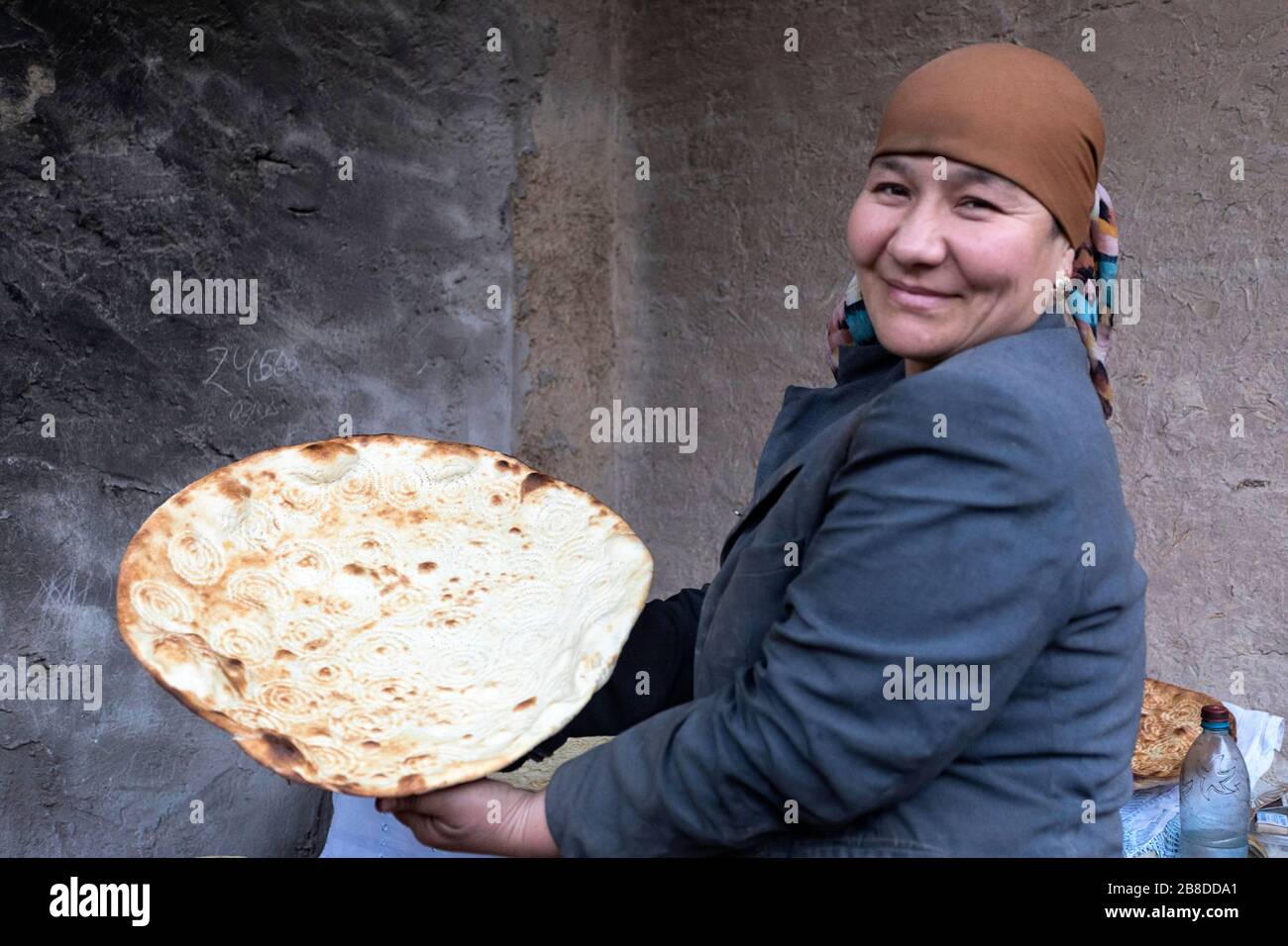 Eine lokale Frau backt traditionelles Brot in EINEM traditionellen Lehmofen, Khiva, Usbekistan Stockfoto