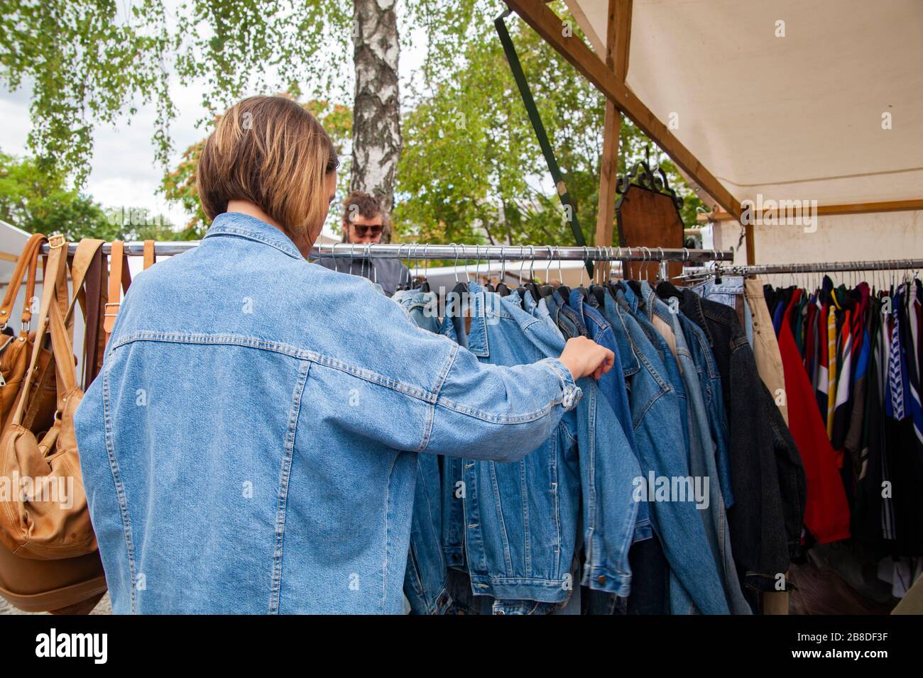 Berlin, Deutschland - 7. Juli 2019: Ein Mädchen auf dem Fleamarket im Mauerpark, das Jeansjacken sieht Stockfoto