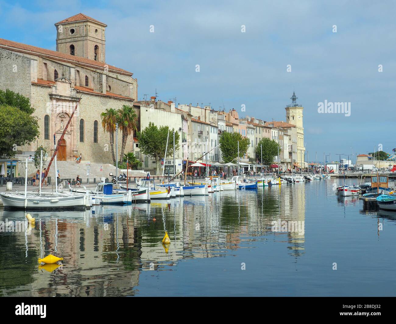 Vieux Port aka alten Hafen in einer mediterranen Stadt La Ciotat in Südfrankreich mit vielen angedockten kleinen Booten und der Hauptkirche der Stadt Stockfoto