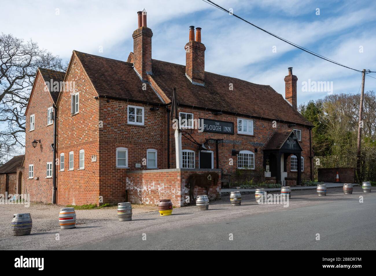 Englisches Pub wegen der Kovid-19-Coronavirus-Pandemie geschlossen, wobei Bierfässer vorne aufgereiht waren. Das Plough Inn, Dorf Little London, Hampshire, Großbritannien Stockfoto