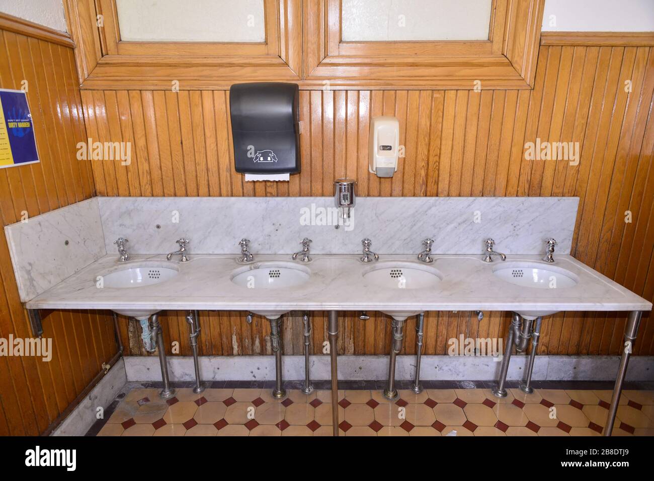 Marmorwaschbecken und Holzvertäfelung in einer öffentlichen Toilette Stockfoto