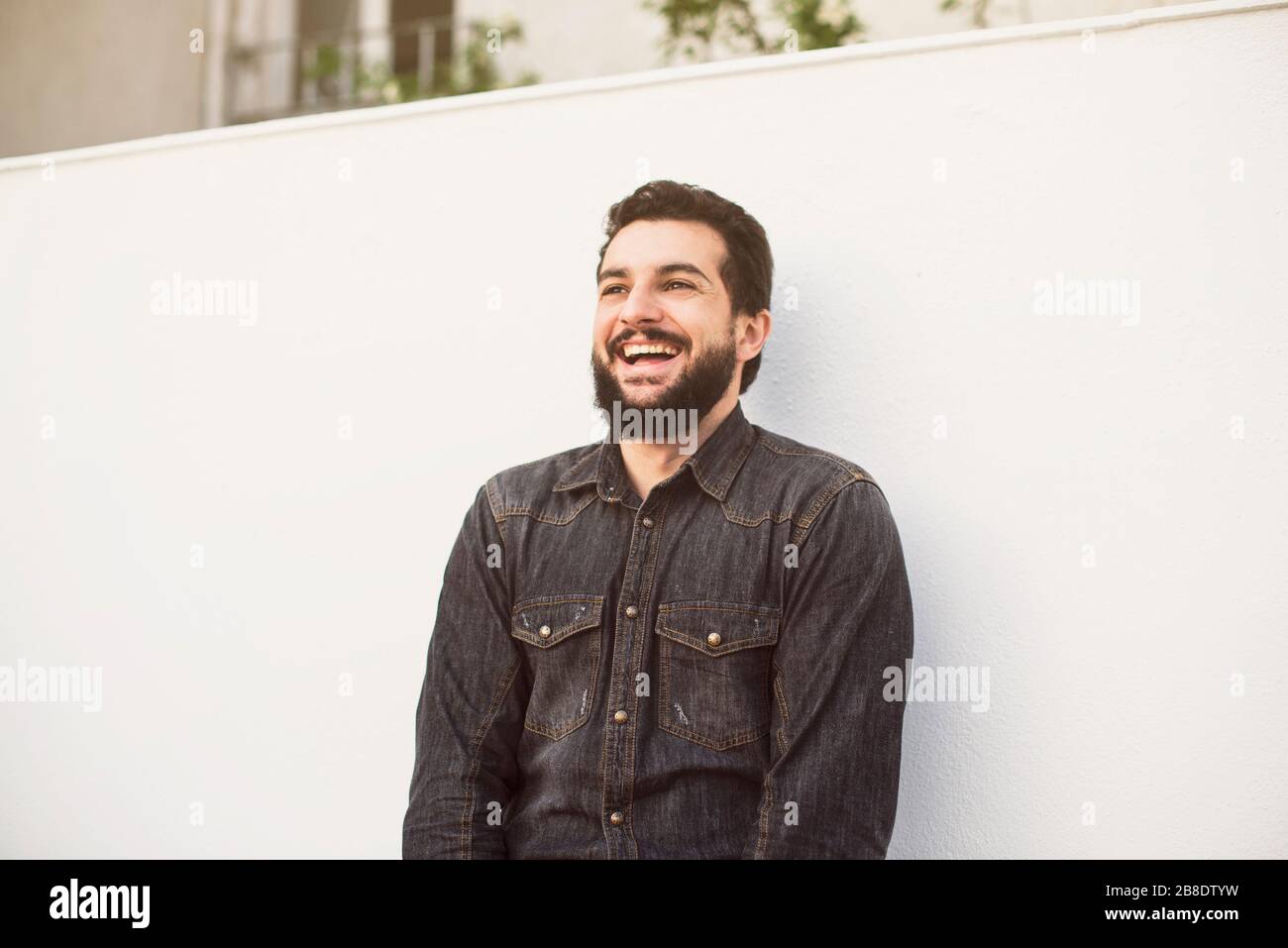Bärtiger Mann lacht im Freien im Terrassenporträt Stockfoto