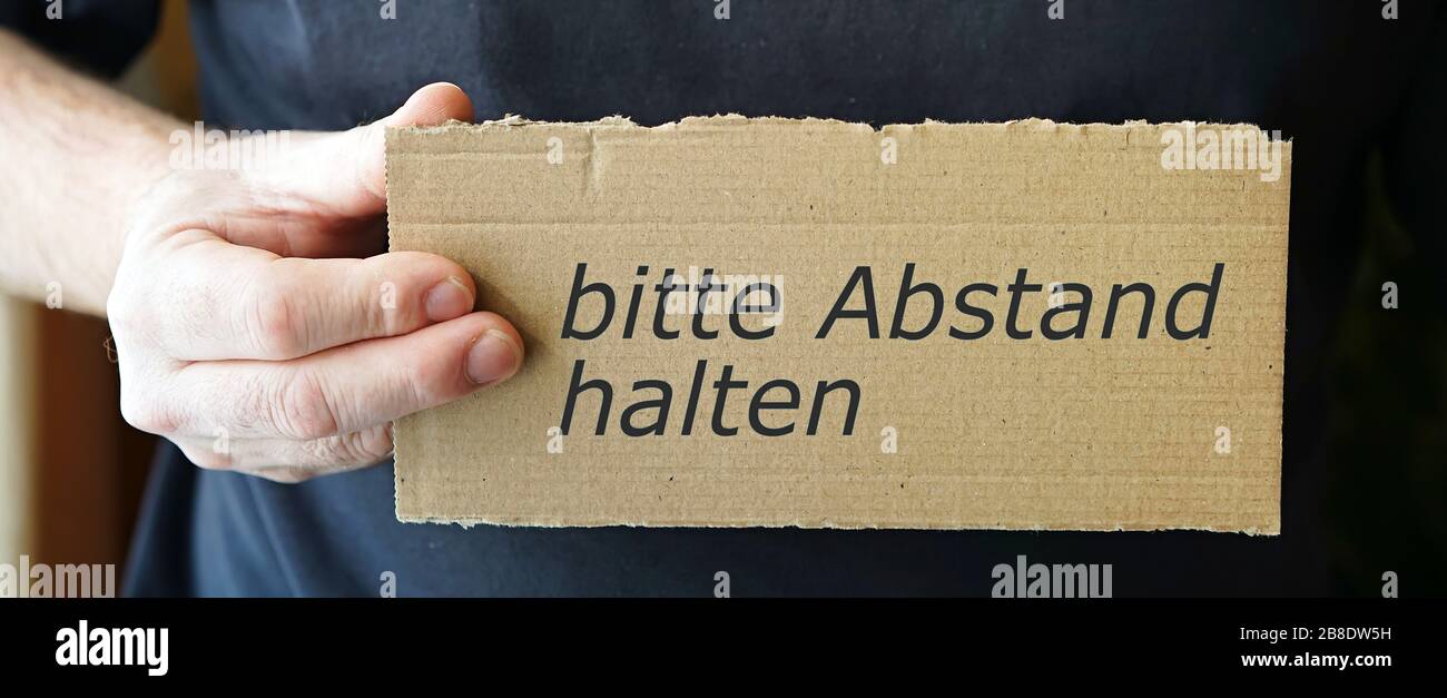 Kartonschild mit der Aufschrift "Bitte Abstand halten" Stockfoto