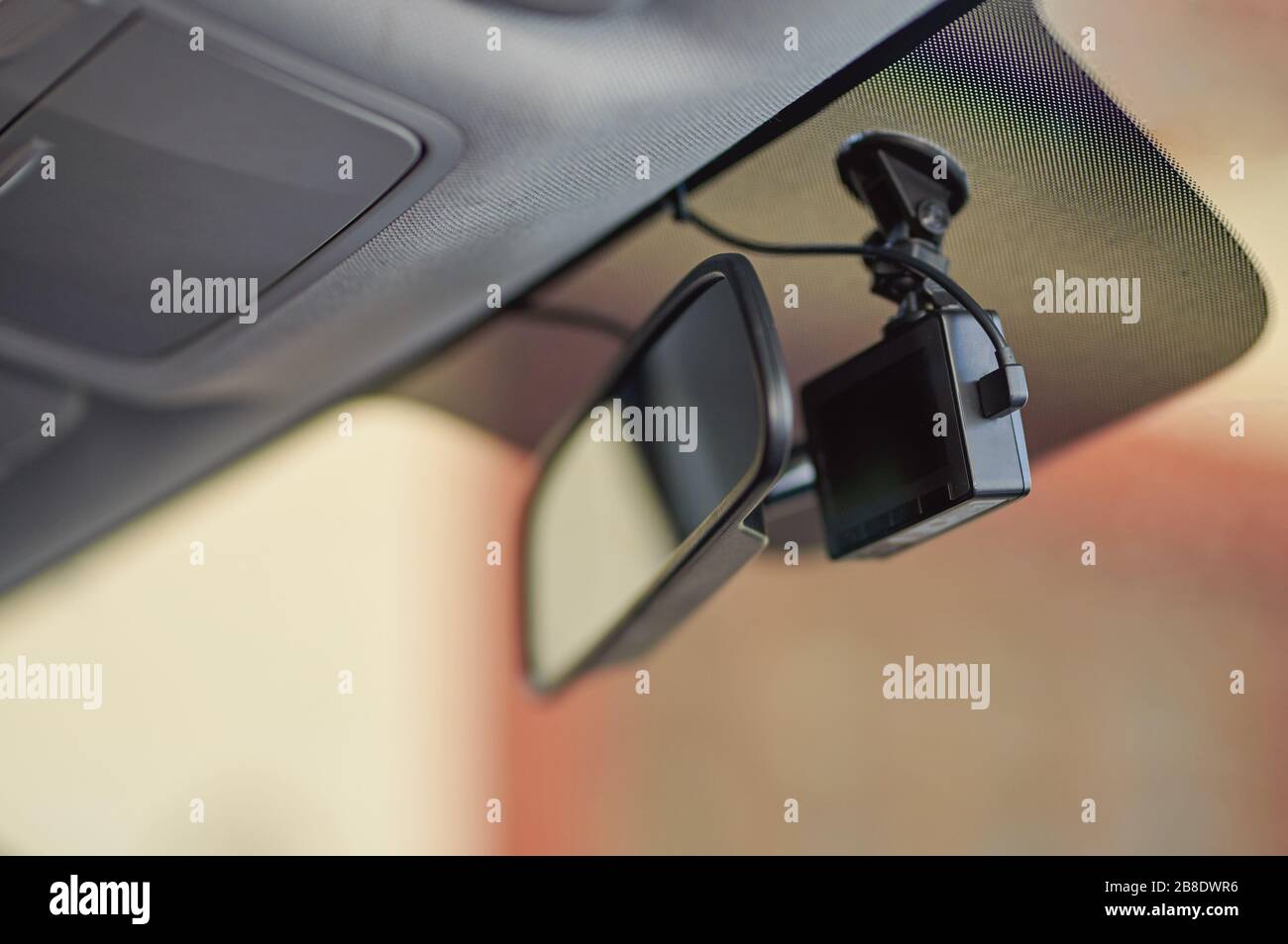 Kleine schwarze Autokamera auf der Windschutzscheibe hinter dem Spiegel Stockfoto