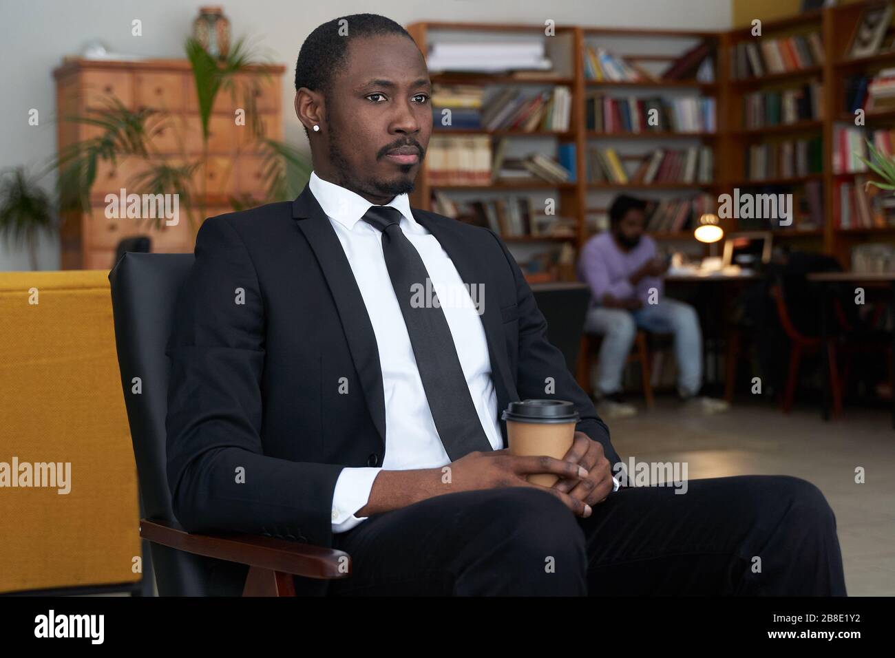 afroamerikanischer Geschäftsmann mit Kaffee in einem Hotelcafé Stockfoto